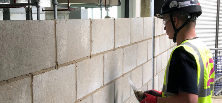 Engineer in high visibility vest inspecting Lignacite concrete wall