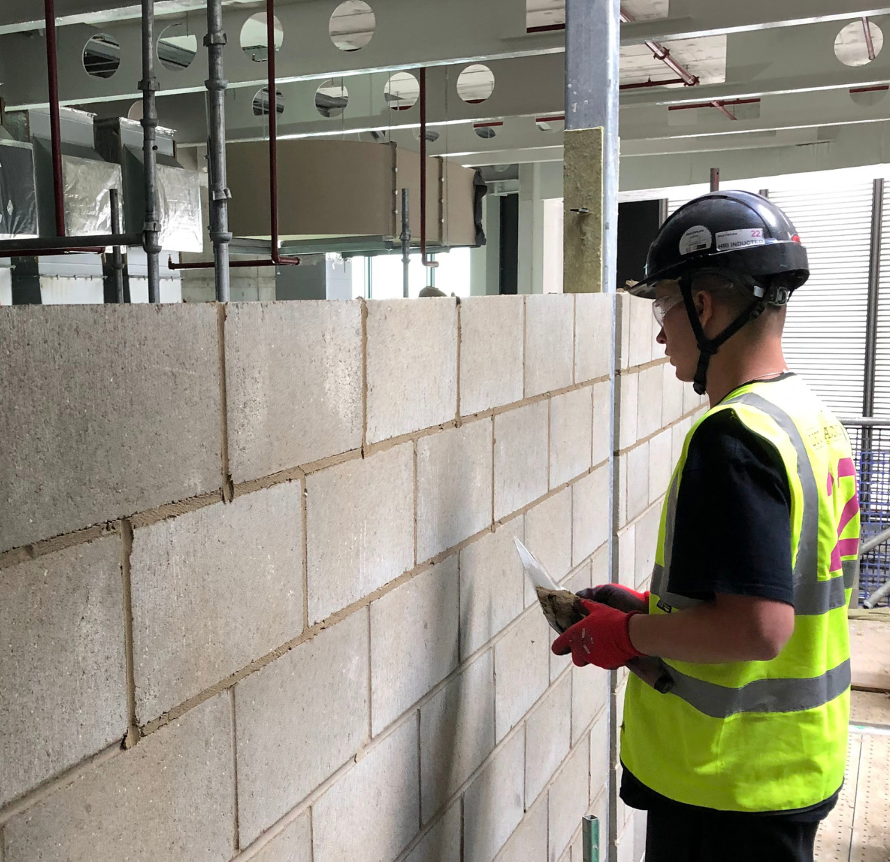 Engineer in high visibility vest inspecting Lignacite concrete wall